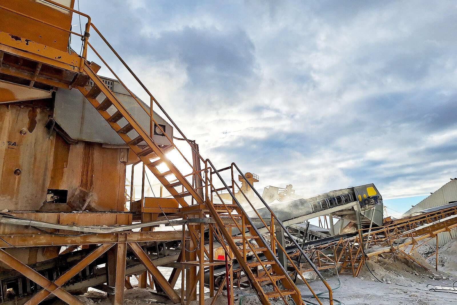 Καταστολή σκόνης με υδρονέφωση υψηλής πίεσης σε ταινιόδρομο λατομείου κατά την τροφοδοσία υλικών